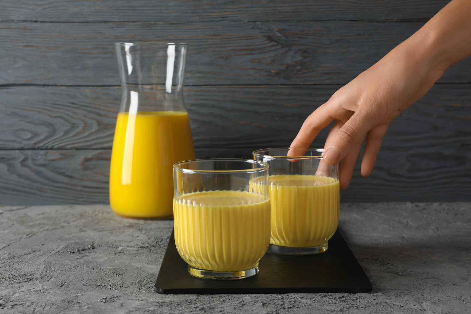 A frothy bright yellow cup of Golden Milk, made with Gathering Place Turmeric Powder